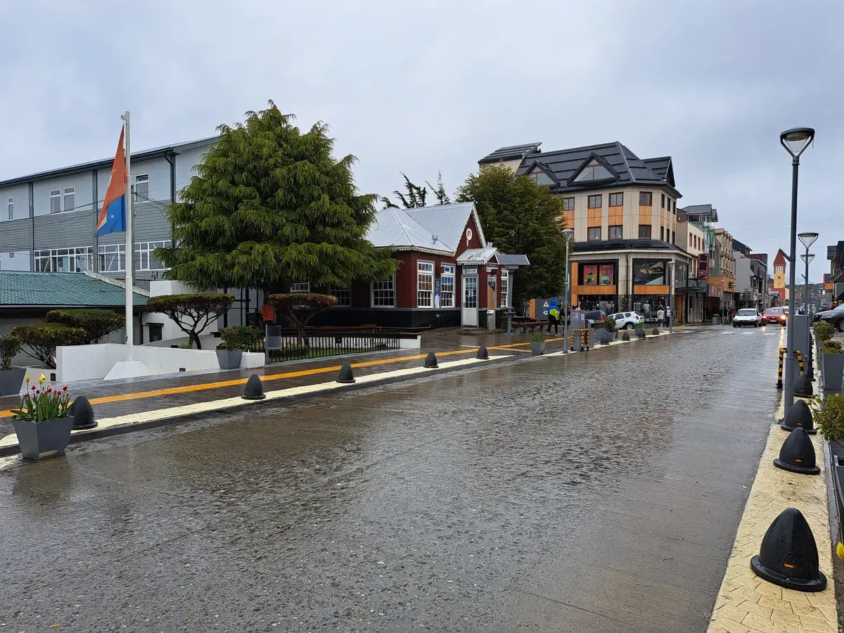 Avenida San Martin in central Ushuaia with its shops and restaurants under an evening sky, Argentina